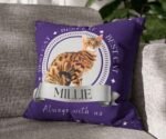 Purple personalized cat photo pillow with "Best Cat" text, resting on a couch.