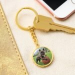 Close-up of a personalized dog photo keychain with an 18k yellow gold finish, featuring a custom photo of a dog and engraved text. This elegant keychain makes for a meaningful and stylish keepsake for dog owners.