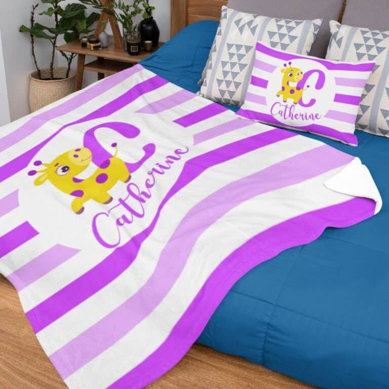 Little giraffe monogrammed blanket with purple stripes on a bed