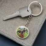 Close-up view of a personalized dog photo keychain in surgical steel, showcasing a custom image of a dog with engraved text