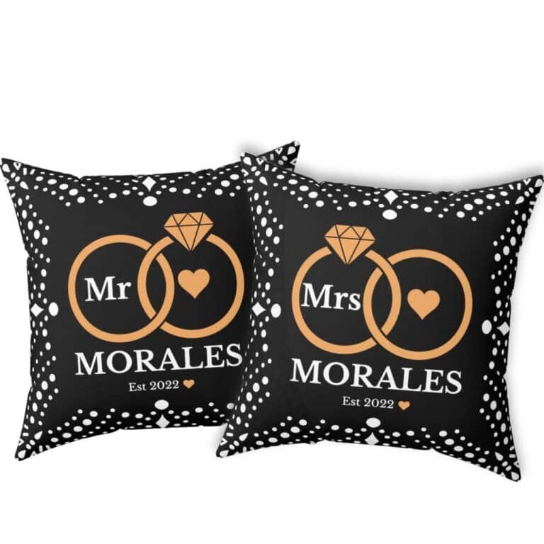 Here’s the corrected version: Black custom wedding pillows featuring intertwined rings, the couple's last name, and the year of marriage