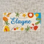 Custom beach theme towel for girl laid flat on sand