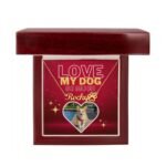 Gold-finish dog name and paw print necklace with dog photo, set against a red background, elegantly displayed in a luxury gift box