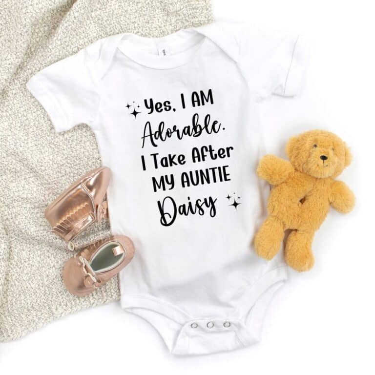 Personalized short-sleeve white auntie onesie for baby girl, laid out flat
