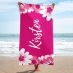 Floral custom towel with name, personalized beach towel for women, displayed on sand with vibrant feminine design